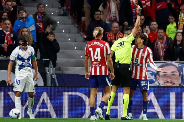 Spanish referee Jose Maria Sanchez Martinez presents a yellow card to Atletico Madrid's Argentine forward #20 Giuliano Simeone during the Spanish league football match between Club Atletico de Madrid and RC Deportivo de la Coruna at Metropolitano Stadium in Madrid on October 24, 2026. (Photo by Oscar DEL POZO / AFP)