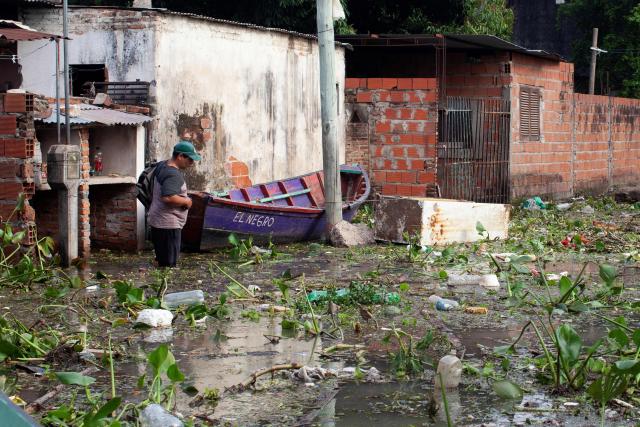 A man walks amid a flood waters after the overflow of the Parana river, following heavy rainfall and the opening of the floodgates at the Yacyreta hydroelectric dam, in Corrientes, Argentina on October 23, 2026. More than 2,000 people have been forced to leave their homes due to flooding linked to the El Nino climate phenomenon affecting northeastern Argentina. The emergency caused two deaths last weekend and is expected to persist for the coming months. Heavy rainfall in recent weeks has dangerously increased water levels in the Iguazu, Parana, and Uruguay rivers, which run along northeastern Argentina, forming natural borders with Brazil, Paraguay, and Uruguay before flowing into the Rio de la Plata. (Photo by Joaquin Meabe / AFP)