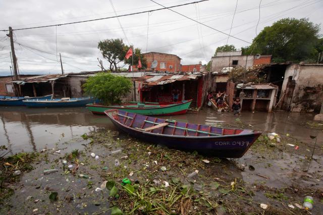 People walk amid a flood after the overflow of the Parana river, following heavy rainfall and the opening of the floodgates at the Yacyreta hydroelectric dam, in Corrientes, Argentina on October 24, 2026. More than 2,000 people have been forced to leave their homes due to flooding linked to the El Nino climate phenomenon affecting northeastern Argentina. The emergency caused two deaths last weekend and is expected to persist for the coming months. Heavy rainfall in recent weeks has dangerously increased water levels in the Iguazu, Parana, and Uruguay rivers, which run along northeastern Argentina, forming natural borders with Brazil, Paraguay, and Uruguay before flowing into the Rio de la Plata. (Photo by Joaquin Meabe / AFP)