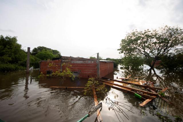 A flooded house is pictured after the overflow of the Parana river, following heavy rainfall and the opening of the floodgates at the Yacyreta hydroelectric dam, in Corrientes, Argentina on October 23, 2026. More than 2,000 people have been forced to leave their homes due to flooding linked to the El Nino climate phenomenon affecting northeastern Argentina. The emergency caused two deaths last weekend and is expected to persist for the coming months. Heavy rainfall in recent weeks has dangerously increased water levels in the Iguazu, Parana, and Uruguay rivers, which run along northeastern Argentina, forming natural borders with Brazil, Paraguay, and Uruguay before flowing into the Rio de la Plata. (Photo by Joaquin Meabe / AFP)