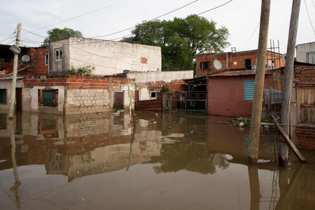 Flooded houses are pictured after the overflow of the Parana river, following heavy rainfall and the opening of the floodgates at the Yacyreta hydroelectric dam, in Corrientes, Argentina on October 23, 2026. More than 2,000 people have been forced to leave their homes due to flooding linked to the El Nino climate phenomenon affecting northeastern Argentina. The emergency caused two deaths last weekend and is expected to persist for the coming months. Heavy rainfall in recent weeks has dangerously increased water levels in the Iguazu, Parana, and Uruguay rivers, which run along northeastern Argentina, forming natural borders with Brazil, Paraguay, and Uruguay before flowing into the Rio de la Plata. (Photo by Joaquin Meabe / AFP)