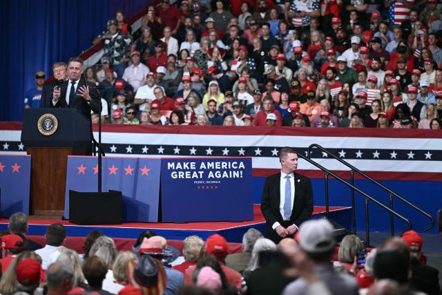 US President Donald Trump looks on as CEO of Audi AG Gernot Dollner speaks at a midterm election campaign rally at Guardian Centers of Georgia in Perry, Georgia on October 24, 2026. President Trump is traveling around the country to try to give a boost to Republicans in tight midterm races. (Photo by Brendan SMIALOWSKI / AFP)