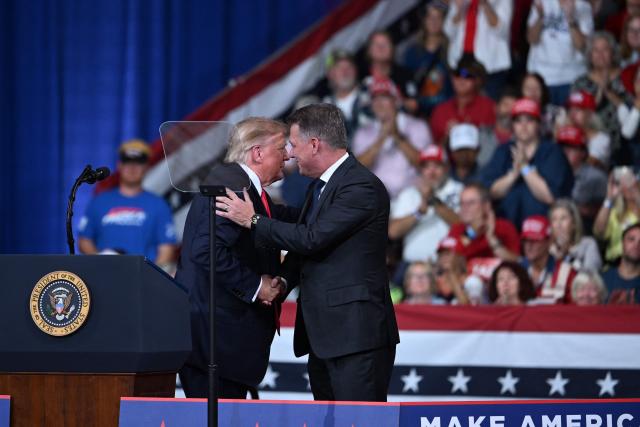 US President Donald Trump greets CEO of Audi AG Gernot Dollner at a midterm election campaign rally at Guardian Centers of Georgia in Perry, Georgia on October 24, 2026. President Trump is traveling around the country to try to give a boost to Republicans in tight midterm races. (Photo by Brendan SMIALOWSKI / AFP)