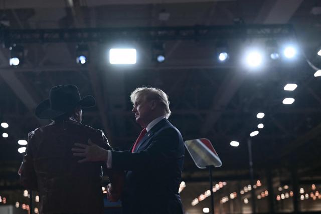 US country musician Jason Aldean greets US President Donald Trump at a midterm election campaign rally at Guardian Centers of Georgia in Perry, Georgia on October 24, 2026. President Trump is traveling around the country to try to give a boost to Republicans in tight midterm races. (Photo by Brendan SMIALOWSKI / AFP)