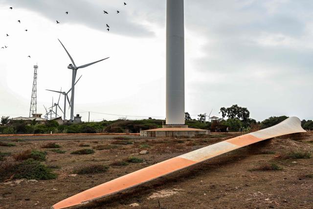 This photograph taken on October 2, 2026 shows a turbine blade lying near a wind power plant in Sri Lanka's Mannar Peninsula. The government aims to generate 70 percent of the country's electricity from renewable sources by 2030, including wind power. But it has frozen new projects in Mannar to ease local opposition. Since they appeared six years ago, the Mannar wind turbines have been blamed for a host of problems -- from dwindling catches to floods, fuelling opposition to green energy projects as fuel costs soar. (Photo by Ishara S. KODIKARA / AFP)