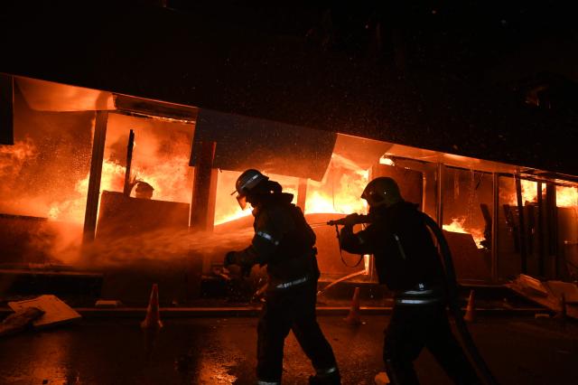 Ukrainian firefighters extinguish a blaze at Epicentr hypermarket that was damaged following a Russian air attack, in Kharkiv, late on October 24, 2026, amid the Russian invasion of Ukraine. (Photo by SERGEY BOBOK / AFP)