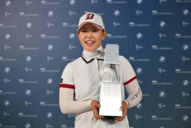 Yuri Yoshida of Japan poses with the trophy after her victory in the LPGA Tour - BMW Ladies Championship golf tournament at Pine Beach Golf Links in Haenam on October 25, 2026. (Photo by Jung Yeon-je / AFP)