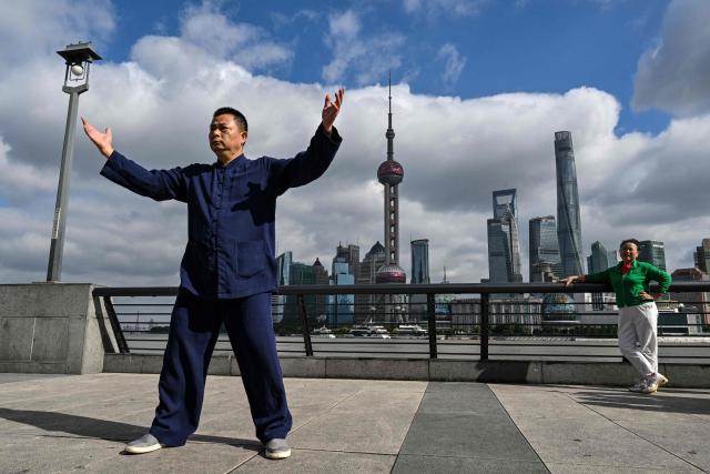 A man practices Tai Chi on The Bund promenade along the Huangpu river in Shanghai on October 25, 2026. (Photo by Hector RETAMAL / AFP)