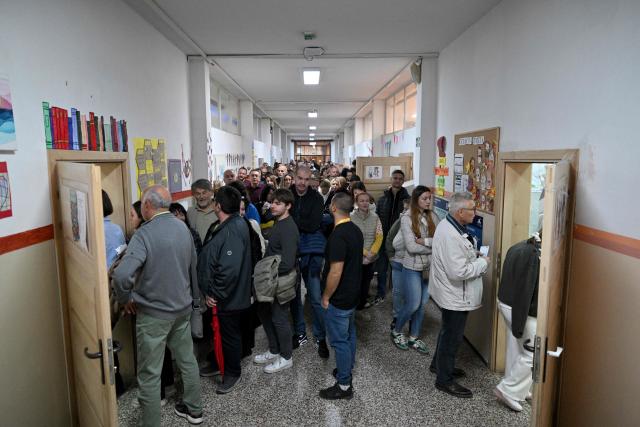 Voters queue at a polling station to cast their ballots for Serbia's snap parliamentary elections in Belgrade on October 25, 2026. The vote is the culmination of nearly two years of student-led protests sparked by the 2024 collapse of a canopy at Novi Sad railway station that killed 16 people, a tragedy widely blamed on corruption. (Photo by Andrej ISAKOVIC / AFP)