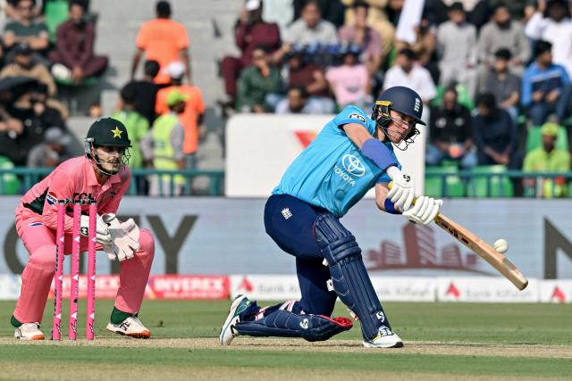 England's Sam Curran (R) plays a shot as Pakistan's wicketkeeper Saad Baig fields during the one-day international (ODI) tri-series cricket match between Pakistan and England at the Gaddafi Stadium in Lahore on October 25, 2026. (Photo by ARIF ALI / AFP)