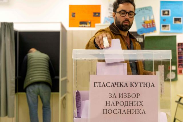 A voter casts a ballot at a polling station for Serbia's snap parliamentary elections in Belgrade on October 25, 2026. The vote is the culmination of nearly two years of student-led protests sparked by the 2024 collapse of a canopy at Novi Sad railway station that killed 16 people, a tragedy widely blamed on corruption. (Photo by Milos Milanovic / AFP)