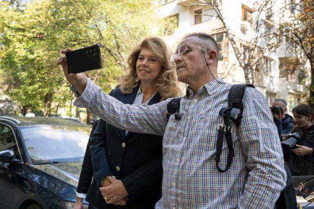 Bulgaria's incumbent President and Presidential candidate Iliana Iotova (L) poses for a selfie with a sympathiser after voting for the presidential election at a polling station in Sofia, on October 25, 2026. Bulgarians are voting in a presidential election on October 25, as security concerns swirl following a series of drone attacks on ships in the Black Sea. The incumbent President, who favors dialogue with Moscow and opposes military aid to Ukraine, is the frontrunner for a new term in the largely ceremonial post, polls show. (Photo by Nikolay DOYCHINOV / AFP)