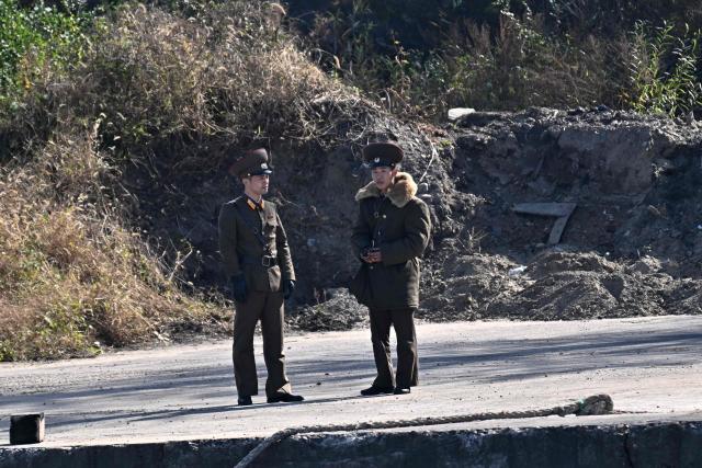 North Korean soldiers stand on the waterfront of the Yalu River in the North Korean town of Sinuiju, viewed from the border city of Dandong, in China's northeast Liaoning province, on October 25, 2026.  (Photo by Pedro PARDO / AFP)