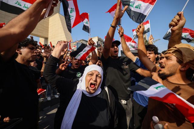 Protesters shout slogans as they wave flags of Iraq as they gather in Baghdad's Tahrir Square on October 25, 2026 to mark the 7th anniversary of the 2019 Iraqi anti-government demonstrations. (Photo by AHMAD AL-RUBAYE / AFP)