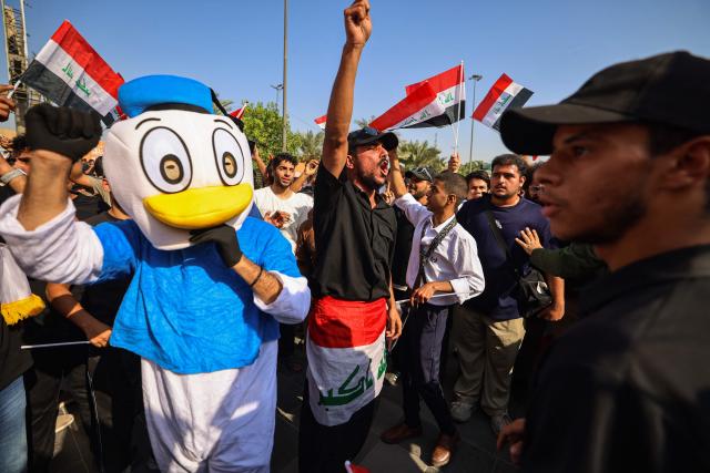 Protesters shout slogans as they wave flags of Iraq as they gather in Baghdad's Tahrir Square on October 25, 2026 to mark the 7th anniversary of the 2019 Iraqi anti-government demonstrations. (Photo by AHMAD AL-RUBAYE / AFP)