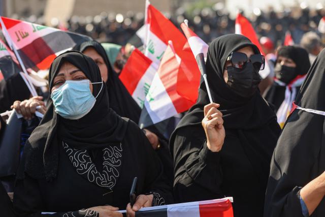 Protesters wave flags of Iraq as they gather in Baghdad's Tahrir Square on October 25, 2026 to mark the 7th anniversary of the 2019 Iraqi anti-government demonstrations. (Photo by AHMAD AL-RUBAYE / AFP)