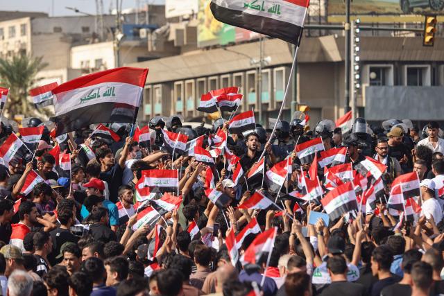 Protesters shout slogans as they wave flags of Iraq as they gather in Baghdad's Tahrir Square on October 25, 2026 to mark the 7th anniversary of the 2019 Iraqi anti-government demonstrations. (Photo by AHMAD AL-RUBAYE / AFP)