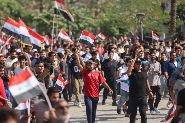 Protesters wave flags of Iraq as they gather in Baghdad's Tahrir Square on October 25, 2026 to mark the 7th anniversary of the 2019 Iraqi anti-government demonstrations. (Photo by AHMAD AL-RUBAYE / AFP)