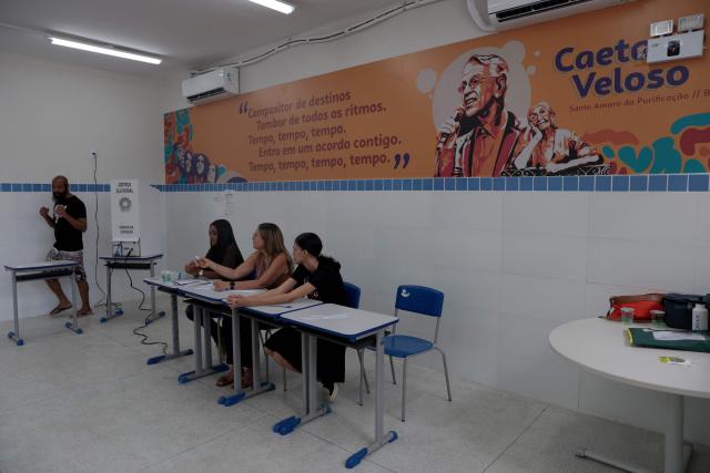 A man gestures after casting his vote at a polling station during the presidential runoff election in Salvador, Bahia state, Brazil, on October 25, 2026. Brazilians head to the polls for a runoff between President Luiz Inacio Lula da Silva and right-wing senator Flavio Bolsonaro that will determine whether Brazil remains one of the few leftist nations in the region or joins a regional swing to the right championed by US President Donald Trump, a Bolsonaro ally. (Photo by Antonello VENERI / AFP)