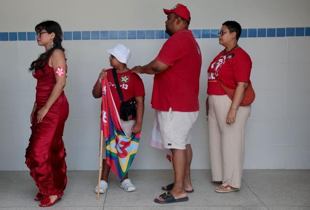 Supporters of Brazil's President and Workers' Party (PT) and re-election candidate Luiz Inacio Lula da Silva wait to vote at a polling station during the presidential runoff election in Salvador, Bahia state, Brazil, on October 25, 2026. Brazilians head to the polls for a runoff between President Luiz Inacio Lula da Silva and right-wing senator Flavio Bolsonaro that will determine whether Brazil remains one of the few leftist nations in the region or joins a regional swing to the right championed by US President Donald Trump, a Bolsonaro ally. (Photo by Antonello VENERI / AFP)