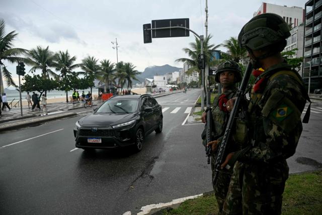 Soldiers patrol along Ipanema beach in Rio de Janeiro, Brazil, on October 25, 2026, on the day of the presidential runoff election. Brazilians head to the polls for a runoff between President Luiz Inacio Lula da Silva and right-wing senator Flavio Bolsonaro that will determine whether Brazil remains one of the few leftist nations in the region or joins a regional swing to the right championed by US President Donald Trump, a Bolsonaro ally. (Photo by MAURO PIMENTEL / AFP)