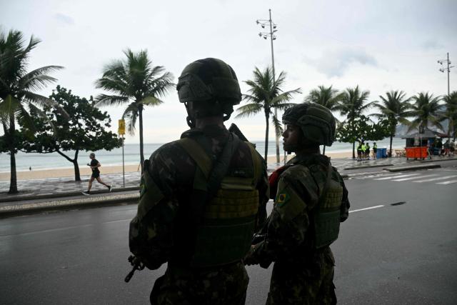 Soldiers patrol along Ipanema beach in Rio de Janeiro, Brazil, on October 25, 2026, on the day of the presidential runoff election. Brazilians head to the polls for a runoff between President Luiz Inacio Lula da Silva and right-wing senator Flavio Bolsonaro that will determine whether Brazil remains one of the few leftist nations in the region or joins a regional swing to the right championed by US President Donald Trump, a Bolsonaro ally. (Photo by MAURO PIMENTEL / AFP)