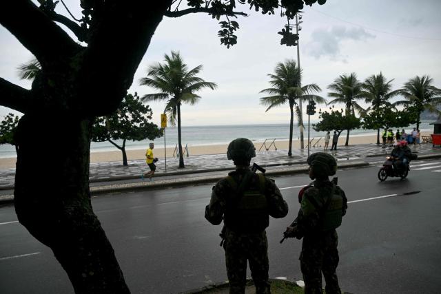 Soldiers patrol along Ipanema beach in Rio de Janeiro, Brazil, on October 25, 2026, on the day of the presidential runoff election. Brazilians head to the polls for a runoff between President Luiz Inacio Lula da Silva and right-wing senator Flavio Bolsonaro that will determine whether Brazil remains one of the few leftist nations in the region or joins a regional swing to the right championed by US President Donald Trump, a Bolsonaro ally. (Photo by MAURO PIMENTEL / AFP)