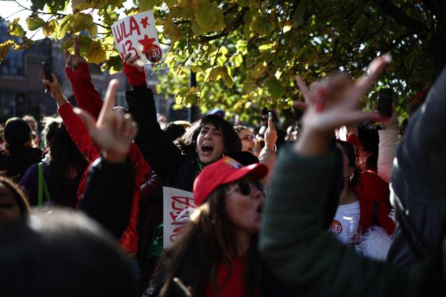 Supporters of Lula sing and dance outside the vote centre as voters arrive to cast their ballots in the Brazilian presidential election runoff at West London College, on October 25, 2026. The election outcome could see Latin America's largest country join a regional shift to the right championed by the US President, or remain a left-wing stronghold. (Photo by Henry NICHOLLS / AFP)