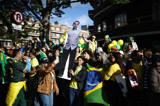 Supporters of Flavio Bolsonaro sing and dance outside the vote centre as voters arrive to cast their ballots in the Brazilian presidential election runoff at West London College, on October 25, 2026. The election outcome could see Latin America's largest country join a regional shift to the right championed by the US President, or remain a left-wing stronghold. (Photo by Henry NICHOLLS / AFP)