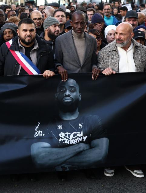 Attendees and officials including mayor of Aubervilliers Sofienne Karroumi (L) and Saint-Denis Mayor Bally Bagayoko take part in a silent march in tribute to Pengo Bossio Wangi, a man killed in a shooting by an attacker on October 23, a march organised by his MMA club near the town hall of Aubervilliers, north of Paris, on October 25, 2026. A man suspected of a gun attack in the Paris suburbs that killed Pengo Bossio Wangi and wounded five other persons has left custody and been placed in a psychiatric unit for observation, French anti-terror prosecutors said on October 25, 2026. The 39-year-old suspect, partly identified as Kevin T., was arrested on October 23, in possession of a submachine gun and tear-gas grenades in his car, shortly after the victims were shot as a vehicle drove through the working-class town of Trappes and neighbouring La Verriere. (Photo by Sameer AL-DOUMY / AFP)