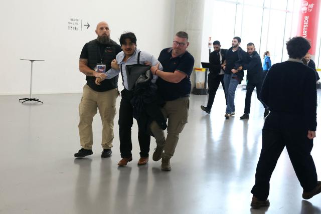 Security staff evacuate gets protesters out of the launch rally for Marine Le Pen’s presidential campaign as part of the Congress of the Far-right party Rassemblement National (RN) in Orleans, central France on October 25, 2026. (Photo by Alain JOCARD / AFP)
