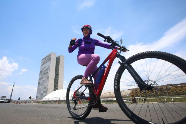 A cyclist rides in front of the National Congress building in Brasilia, on October 25, 2026, during the presidential runoff election. Brazilians head to the polls for a runoff between President Luiz Inacio Lula da Silva and right-wing senator Flavio Bolsonaro that will determine whether Brazil remains one of the few leftist nations in the region or joins a regional swing to the right championed by US President Donald Trump, a Bolsonaro ally. (Photo by Igo ESTRELA / AFP)