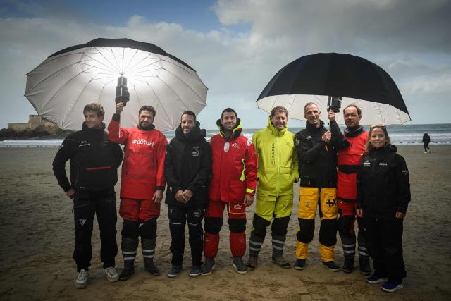 (From L) "SVR-Lazartigue" Ultim class French sailor Tom Laperche, "Actual Ultim 4" Ultim class French sailor Anthony Marchand, "Ultim Armand Thiery" Ultim Class French sailor Louis Burton, "Liamm" Ultim class French sailor Guirec Soudee,"Maxi Edmond de Rothschild" Ultim Class French sailor Charles Caudrelier, "Maxi Banque Populaire XI" Ultim Class French sailor Armel Le Cleac'h, "Sodebo Ultim 3" Ultim Class French sailor Thomas Coville and "Idec Sport - CIC" Ultim class French skipper Alexia Barrier pose on the sillon beach of Saint-Malo, on October 25, 2026 a few days before the start of the 13 th Route du Rhum - Destination Guadeloupe. From Saint-Malo in Brittany to Pointe-à-Pitre in Guadeloupe, 115 skippers across 6 classes will take the start on November 1, 2026, in this solo transatlantic sailing race. (Photo by Loic VENANCE / AFP)