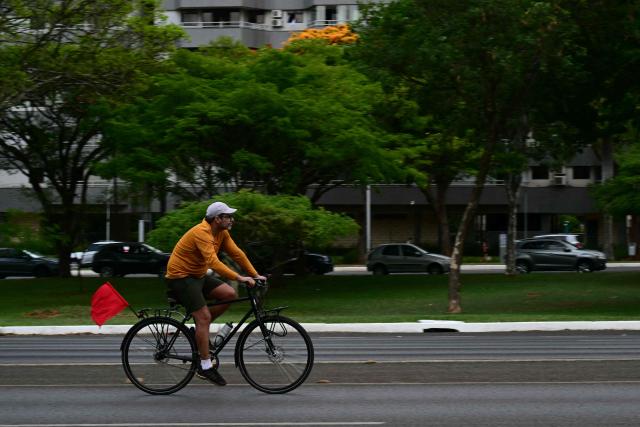A man rides his bike at the Eixo Rodoviario (Eixao) on October 25, 2026. on the day of the presidential runoff election. Brazilians head to the polls for a runoff between President Luiz Inacio Lula da Silva and right-wing senator Flavio Bolsonaro that will determine whether Brazil remains one of the few leftist nations in the region or joins a regional swing to the right championed by US President Donald Trump, a Bolsonaro ally. (Photo by Pablo PORCIUNCULA / AFP)