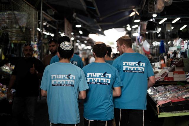 HaDemokratim (The Democrats) party leader Yair Golan's supporters campaign in a market area in Tel Aviv on October 25, 2026, ahead of Israel's legislative election. Israel heads to the polls on October 27 in its first election since the October 7, 2023 Hamas-led attack, in what is seen as a referendum on the prime minister. (Photo by Jewel SAMAD / AFP)