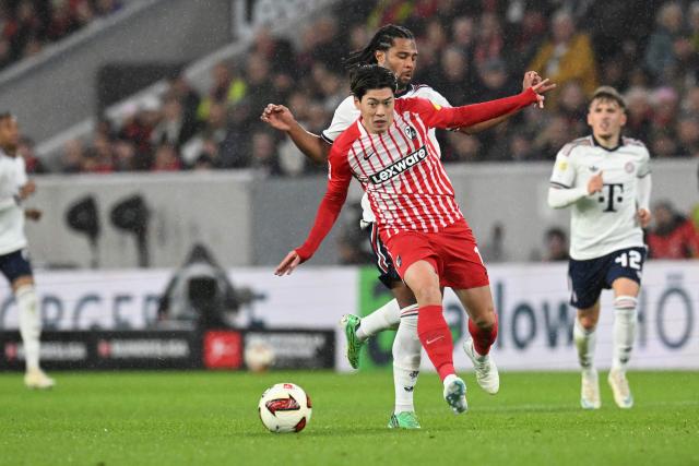 Freiburg's Japanese midfielder #14 Yuito Suzuki (, front) and Bayern Munich's German forward #07 Serge Gnabry (C, back) vie for the ball during the German first division Bundesliga football match between SC Freiburg and FC Bayern Munich in Freiburg, south-western Germany, on October 25, 2026. (Photo by THOMAS KIENZLE / AFP) / DFL REGULATIONS PROHIBIT ANY USE OF PHOTOGRAPHS AS IMAGE SEQUENCES AND/OR QUASI-VIDEO