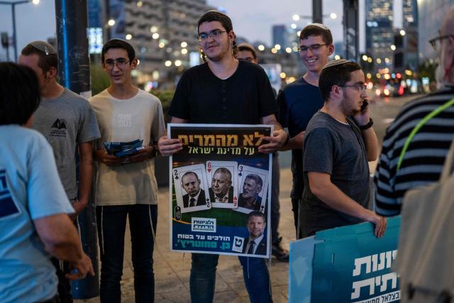 Supporters of the Religious Zionism party led by Israel's Finance Minister Bezalel Smotrich campaign along a steet with in Tel Aviv on October 25, 2026, ahead of Israel's legislative election. Israel heads to the polls on October 27 in its first election since the October 7, 2023 Hamas-led attack, in what is seen as a referendum on the prime minister. (Photo by Jewel SAMAD / AFP)