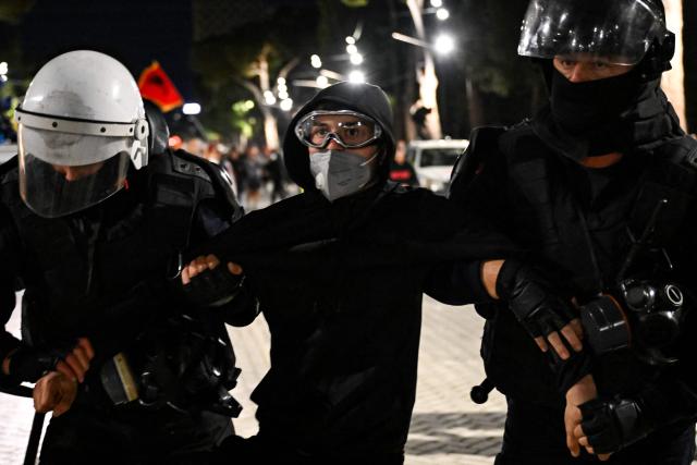 Riot police officers detain a protester during an anti-government demonstration - called by the student-led protest movement to denounce poor study conditions and corruption and to demand prime minister's resignation, in central Tirana on October 25, 2026. (Photo by Armend NIMANI / AFP)