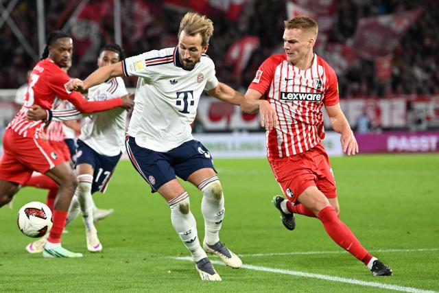 Bayern Munich's English forward #09 Harry Kane (C) and Freiburg's Austrian defender #03 Philipp Lienhart (R) vie for the ball during the German first division Bundesliga football match between SC Freiburg and FC Bayern Munich in Freiburg, south-western Germany, on October 25, 2026. (Photo by THOMAS KIENZLE / AFP) / DFL REGULATIONS PROHIBIT ANY USE OF PHOTOGRAPHS AS IMAGE SEQUENCES AND/OR QUASI-VIDEO