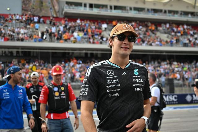 Mercedes' British driver George Russell (R) walks toward the garages after taking part in the drivers' parade before the start of the United States Formula One Grand Prix at the Circuit of the Americas in Austin, Texas, on October 25, 2026. (Photo by ANGELA WEISS / AFP)