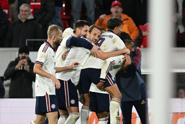 Team mates celebrate Bayern Munich's French midfielder #17 Michael Olise (hidden) after he scored the 1:3 goal during the German first division Bundesliga football match between SC Freiburg and FC Bayern Munich in Freiburg, south-western Germany, on October 25, 2026. (Photo by THOMAS KIENZLE / AFP) / DFL REGULATIONS PROHIBIT ANY USE OF PHOTOGRAPHS AS IMAGE SEQUENCES AND/OR QUASI-VIDEO