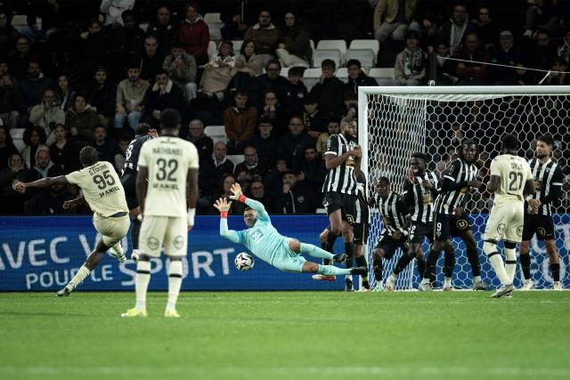 Angers's Portuguese goalkeeper #01 Anthony Lopes dives as Lorient's French defender #95 Isaak Toure shoots a free kick during the French L1 football match between SCO Angers and FC Lorient at the Stade Raymond-Kopa in Angers on October 25, 2026. (Photo by Guillaume SALIGOT / AFP)