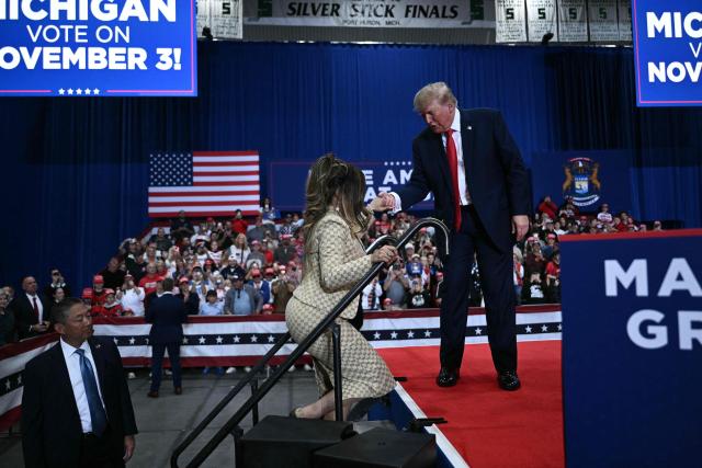 US President Donald Trump helps rapper Nicki Minaj on stage during a campaign rally at the McMorran Place Sports & Entertainment Center in Port Huron, Michigan, on October 25, 2026. (Photo by Brendan SMIALOWSKI / AFP)