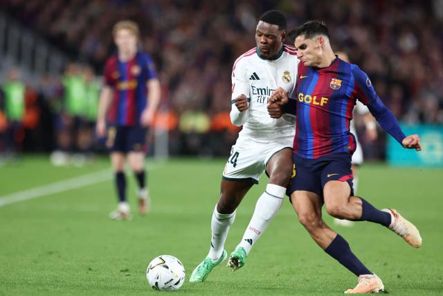 Real Madrid's Dutch defender #24 Denzel Dumfries (L) and Barcelona's Spanish defender #18 Gerard Martin vie for the ball during the Spanish league football match between FC Barcelona and Real Madrid CF at Camp Nou Stadium in Barcelona on October 25, 2026. (Photo by Josep LAGO / AFP)