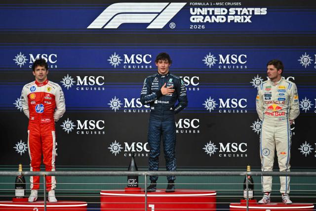 First place winner Mercedes' Italian driver Kimi Antonelli (C) stands alongside second place finisher Ferrari's Monegasque driver Charles Leclerc (L) and third place finisher Red Bull Racing's Dutch driver Max Verstappen (R) on the podium at the conclusion of the United States Formula One Grand Prix at the Circuit of the Americas in Austin, Texas, on October 25, 2026. (Photo by ANGELA WEISS / AFP)