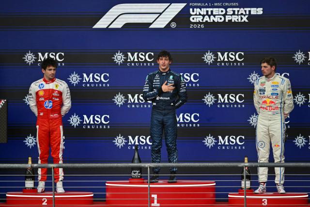 First place winner Mercedes' Italian driver Kimi Antonelli (C) stands alongside second place finisher Ferrari's Monegasque driver Charles Leclerc (L) and third place finisher Red Bull Racing's Dutch driver Max Verstappen (R) on the podium at the conclusion of the United States Formula One Grand Prix at the Circuit of the Americas in Austin, Texas, on October 25, 2026. (Photo by ANGELA WEISS / AFP)