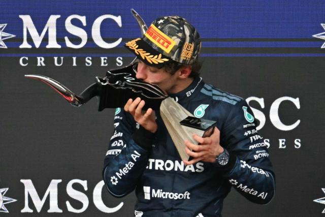 Race winner Mercedes' Italian driver Kimi Antonelli kisses the trophy on the podium at the conclusion of the United States Formula One Grand Prix at the Circuit of the Americas in Austin, Texas, on October 25, 2026. (Photo by ANGELA WEISS / AFP)