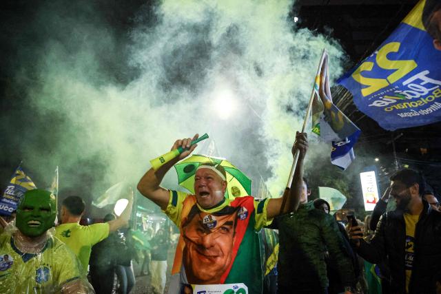 Supporters of Brazil's right-wing Senator and Liberal Party (PL) presidential candidate Flavio Bolsonaro wave flags in Porto Alegre, in the state of Rio Grande do Sul, Brazil, on October 25, 2026, the day of the presidential runoff election. Brazilians head to the polls for a runoff between President Luiz Inacio Lula da Silva and right-wing senator Flavio Bolsonaro that will determine whether Brazil remains one of the few leftist nations in the region or joins a regional swing to the right championed by US President Donald Trump, a Bolsonaro ally. (Photo by SILVIO AVILA / AFP)