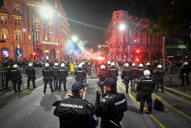 Supporters of the Students’ List face Serbian police celebrate their victory in the Serbian parliamentary elections, in downtown Belgrade on October 25, 2026. Voters cast ballots in record numbers on October 25, 2026, with the country recording its highest parliamentary election turnout in more than three decades. Celebrations erupted on the streets of the capital; passing cars honked their horns as crowds began to party at the news that Serbia's ruling party had lost parliamentary snap elections. (Photo by OLIVER BUNIC / AFP)