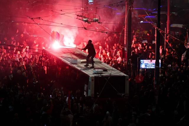 Supporters of the Students’ List light flares as they celebrate their victory in the Serbian parliamentary elections, in downtown Belgrade on October 25, 2026. Voters cast ballots in record numbers on October 25, 2026, with the country recording its highest parliamentary election turnout in more than three decades. Celebrations erupted on the streets of the capital; passing cars honked their horns as crowds began to party at the news that Serbia's ruling party had lost parliamentary snap elections. (Photo by OLIVER BUNIC / AFP)